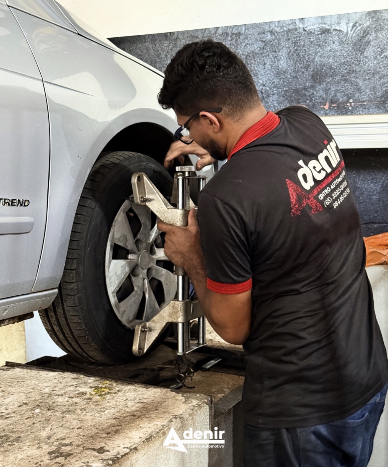 Técnico da Adenir realizando alinhamento 3D na roda de um carro